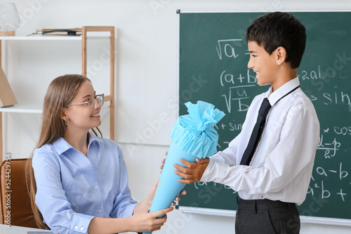 Teacher greeting little boy...
