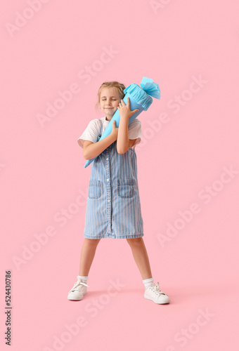 Cute little girl with blue school cone on pink background © Pixel-Shot