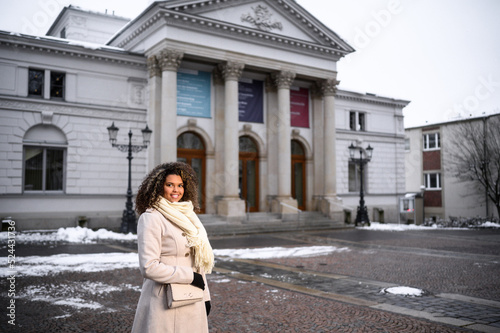 wunderschöne frau vor dem Vogtland Theater Plauen wartet auf Ihre freunde und lächelt