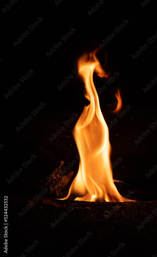 Fire flame on a dark background. Yellow tongues of fire in the fireplace. Flames concept.