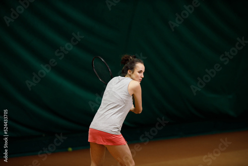 Tennis woman player playing training with racket and ball at court. © primipil