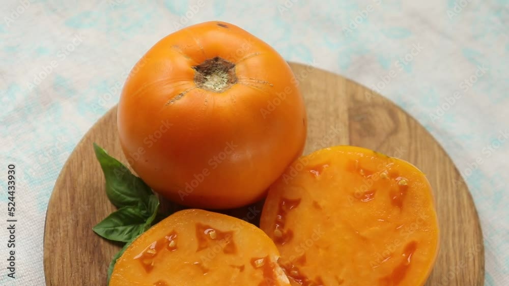 Organic orange-hued tomato close-up selective focus. Organic orange-hued tomato close-up selective focus.
