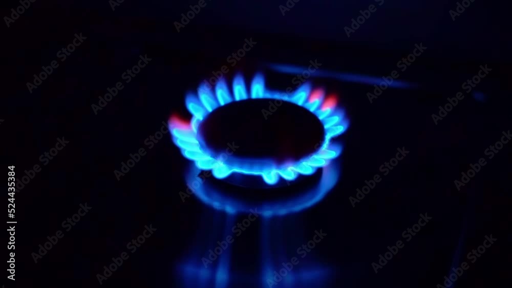 Gas cooktop burning gas stove with blue flame ignited and keeps burning in slow motion Gas cooktop burning gas stove with blue flame ignited and keeps burning in slow motion