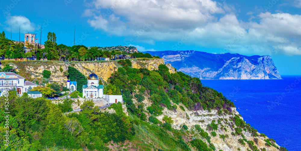 St. George Monastery on Cape Fiolent in the Crimea against the backdrop of beautiful mountains and the Black Sea coast. Summer adventures, travel, active rest at the sea.