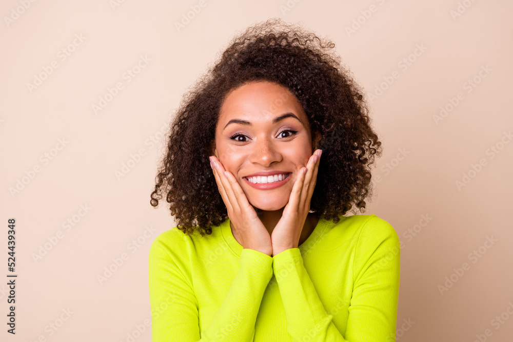Closeup photo of young pretty lady hold cheeks hands smiling toothy beaming looking you isolated on beige color background Closeup photo of young pretty lady hold cheeks hands smiling toothy beaming looking you isolated on beige color background