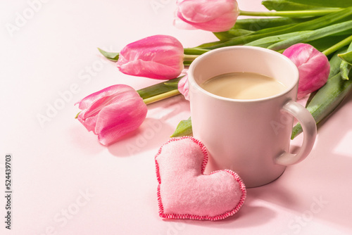 Romantic flat lay composition with a cup of coffee, soft felt hearts, and fresh tulips