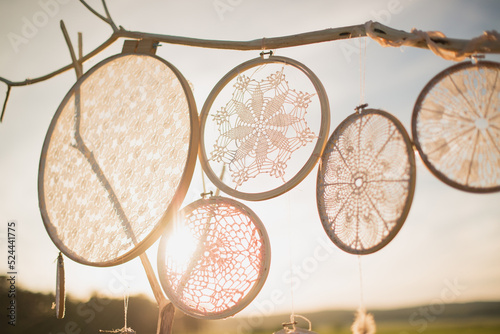 Knitted dream catchers hang on a sunny day