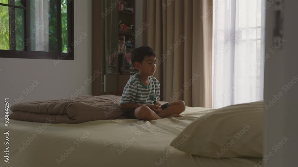 Asian boy practicing meditation in bedroom at home. Asian boy practicing meditation in bedroom at home.