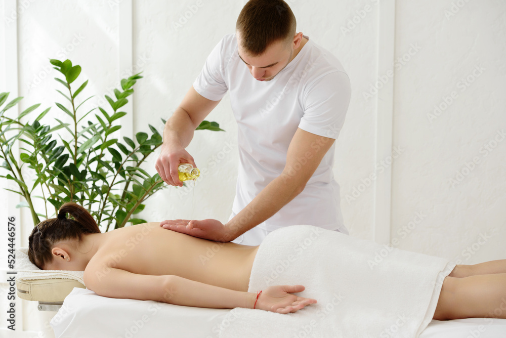 Young pretty woman having back massage in spa, white background. Copy space, closeup Young pretty woman having back massage in spa, white background. Copy space, closeup
