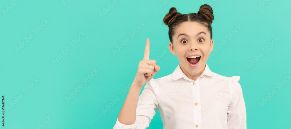 Everything begins with an idea. Happy child keep finger up blue background. Back to school idea. Child face, horizontal poster, teenager girl isolated portrait, banner with copy space. Everything begins with an idea. Happy child keep finger up blue background. Back to school idea. Child face, horizontal poster, teenager girl isolated portrait, banner with copy space.