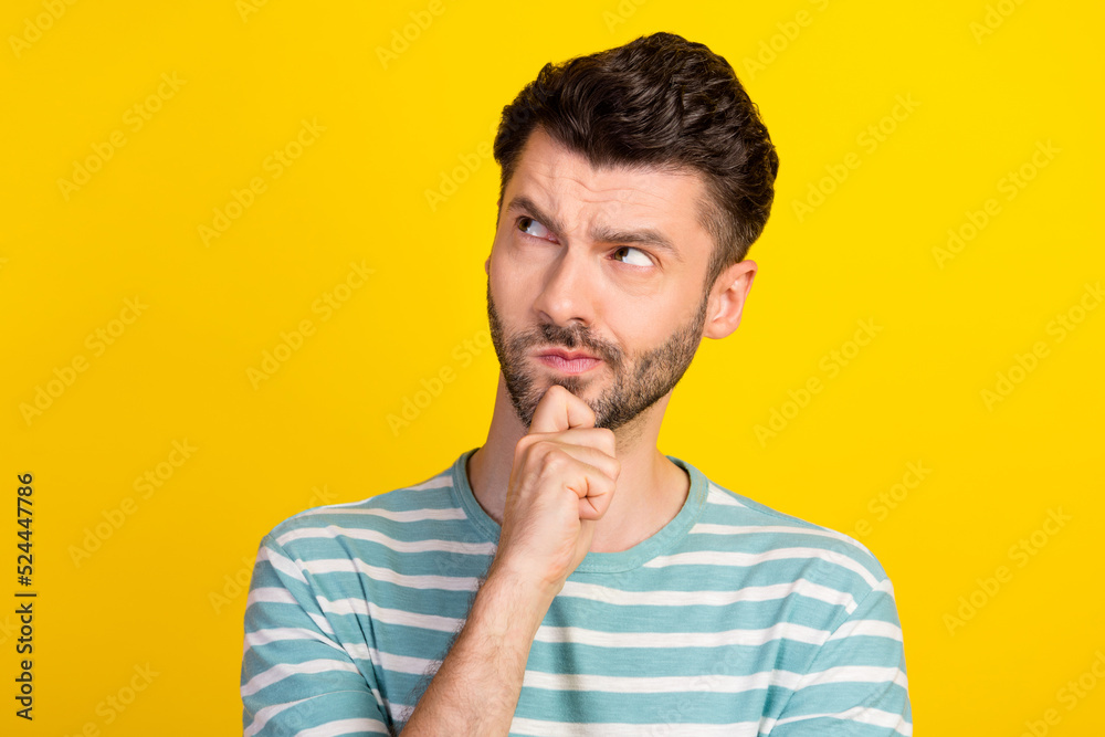 Closeup photo of young handsome man serious minded solve money problem look empty space isolated on yellow color background