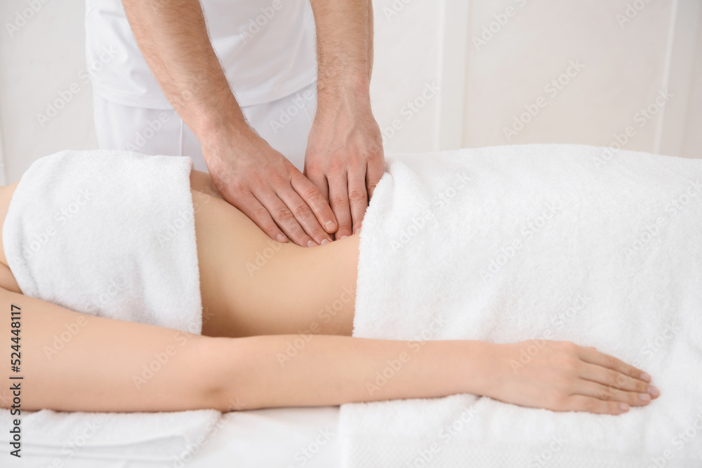 Close up of osteopath doing manipulative massage on woman abdomen on white background, copy space Close up of osteopath doing manipulative massage on woman abdomen on white background, copy space