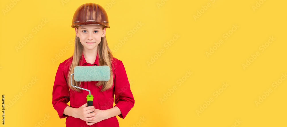 smiling teen child in builder hard hat with paint roller on yellow wall. Child builder in helmet horizontal poster design. Banner header, copy space. smiling teen child in builder hard hat with paint roller on yellow wall. Child builder in helmet horizontal poster design. Banner header, copy space.