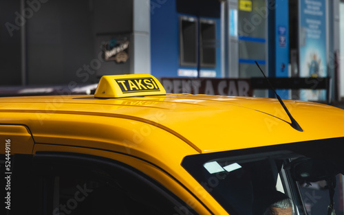 Taxi sign on the roof of a yellow car. Transportation and taxi services