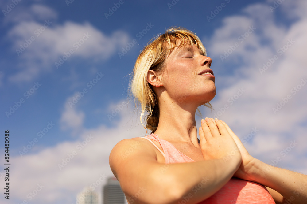 Beautiful young woman practising yoga outside. Fit woman doing stretching exercises at the beach Beautiful young woman practising yoga outside. Fit woman doing stretching exercises at the beach