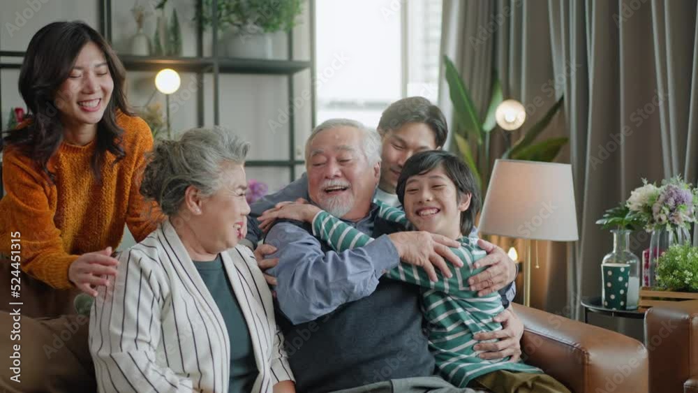 father,mother and boy surprise grandparent mother farther and hug on sofa visiting in living room at home.young daughter greeting and hugging older mother.happiness asian family concept