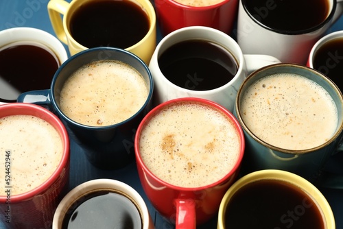 Many cups of different coffee drinks on blue table