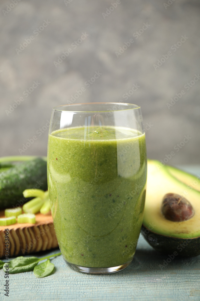 Delicious green juice and fresh ingredients on light blue wooden table Delicious green juice and fresh ingredients on light blue wooden table