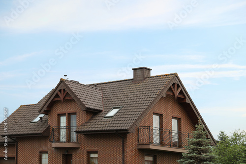 Beautiful house with brown roof against blue sky © New Africa