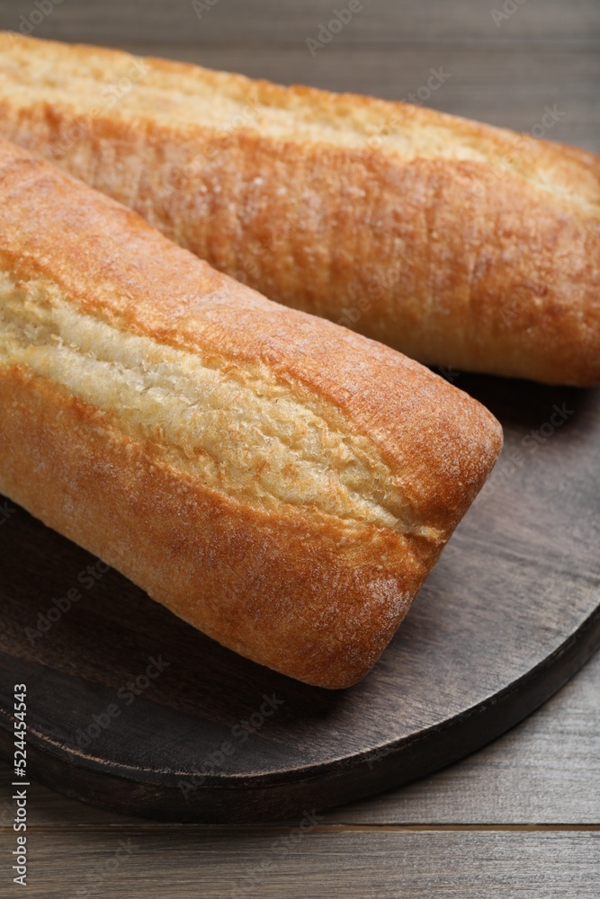 Tasty baguettes on wooden table, closeup. Fresh bread