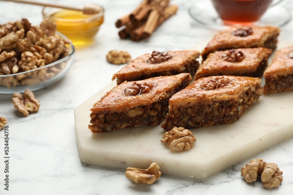 Delicious honey baklava with walnuts on served white marble table, closeup Delicious honey baklava with walnuts on served white marble table, closeup