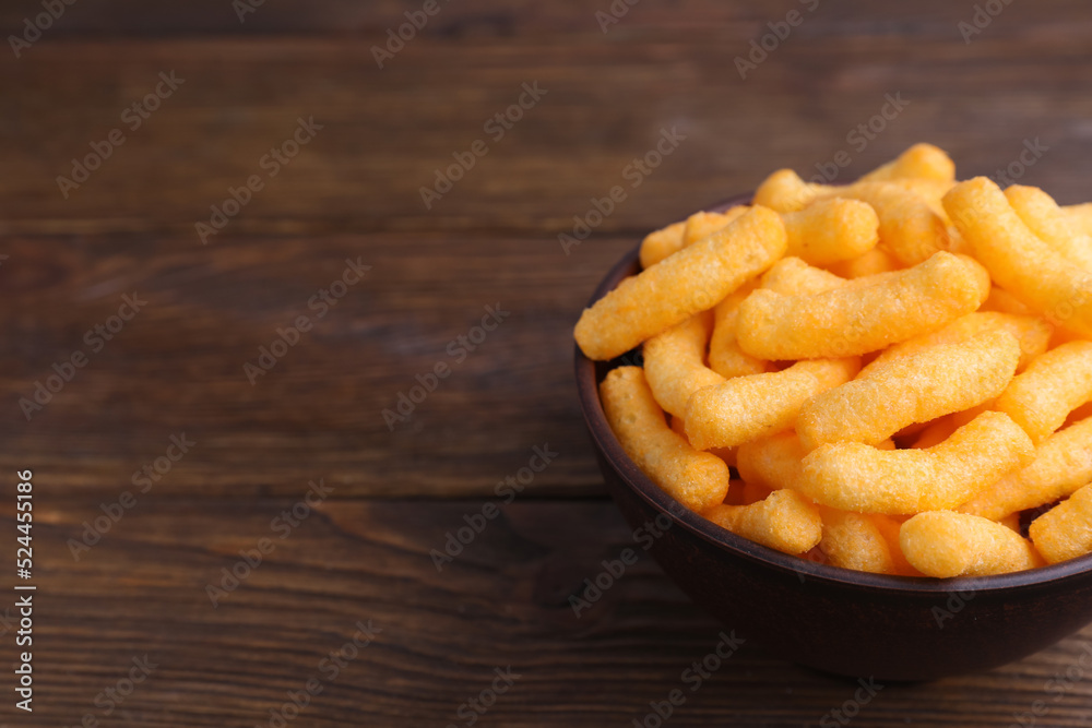 Bowl with crunchy cheesy corn snack on wooden table, closeup. Space for text Bowl with crunchy cheesy corn snack on wooden table, closeup. Space for text