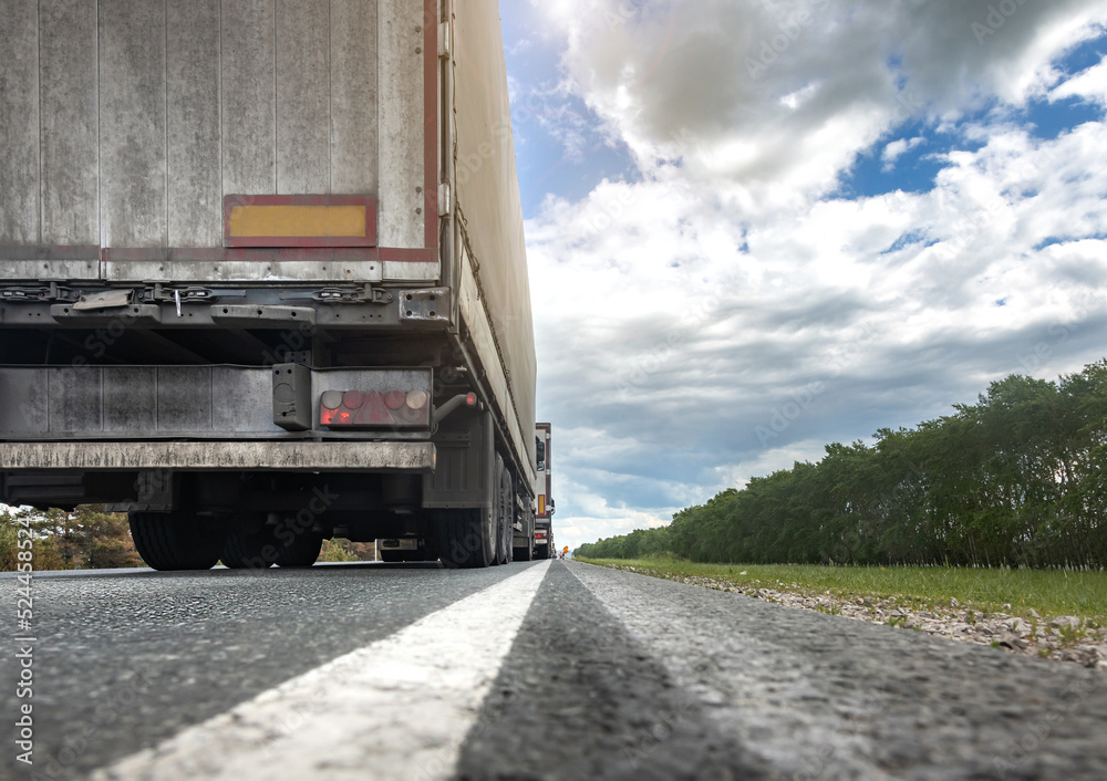 Trucks are stuck in traffic. A column of semitrailers on the freeway