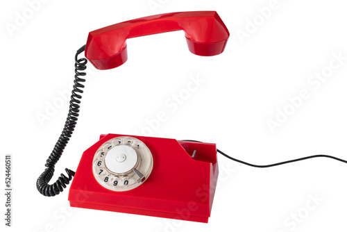 Old red rotary phone with the receiver raised in the air