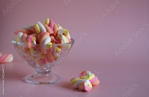dessert airy multi-colored marshmallows in a glass vase on a pink background