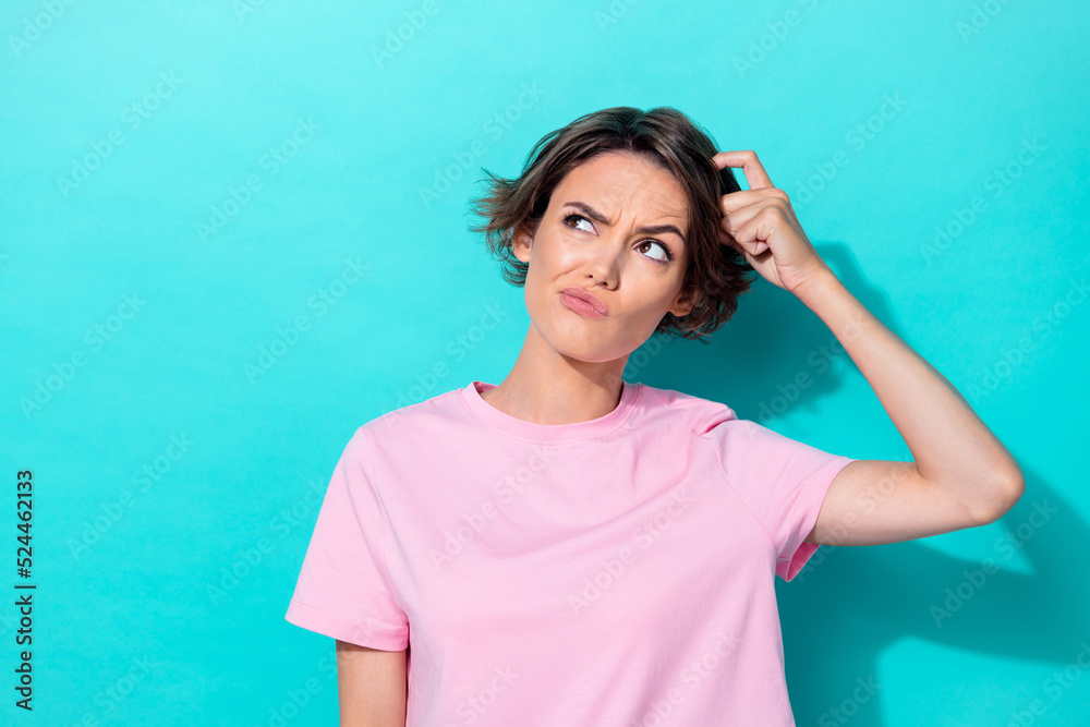 Photo of young attractive cute woman scratch head minded pouted lips look empty space isolated on cyan color background Photo of young attractive cute woman scratch head minded pouted lips look empty space isolated on cyan color background