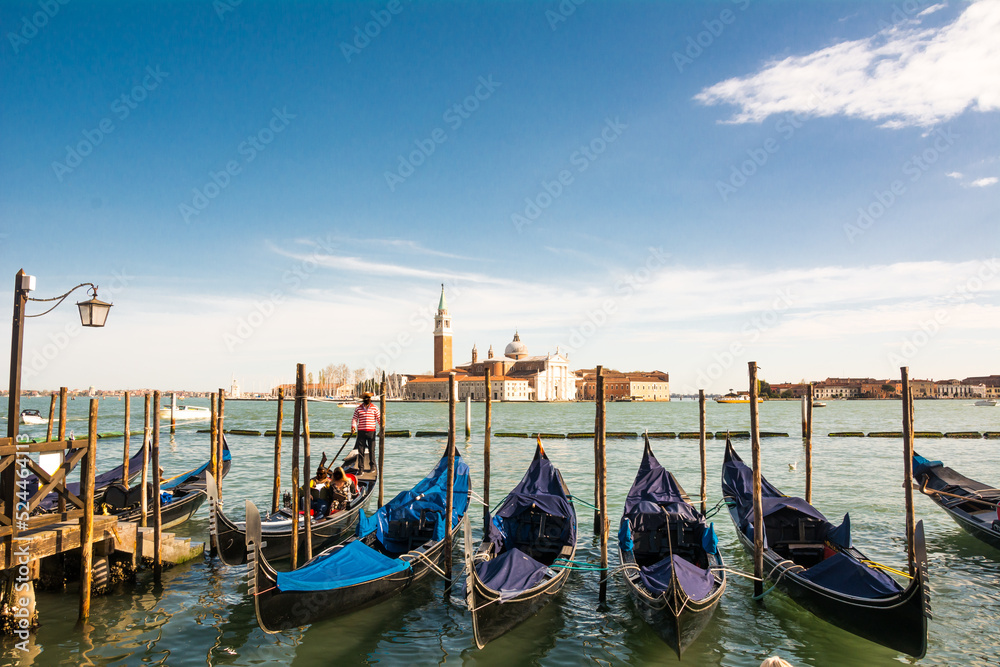Gondolas waiting for tourists at the Grand Canal of Venice, Veneto, Italy.