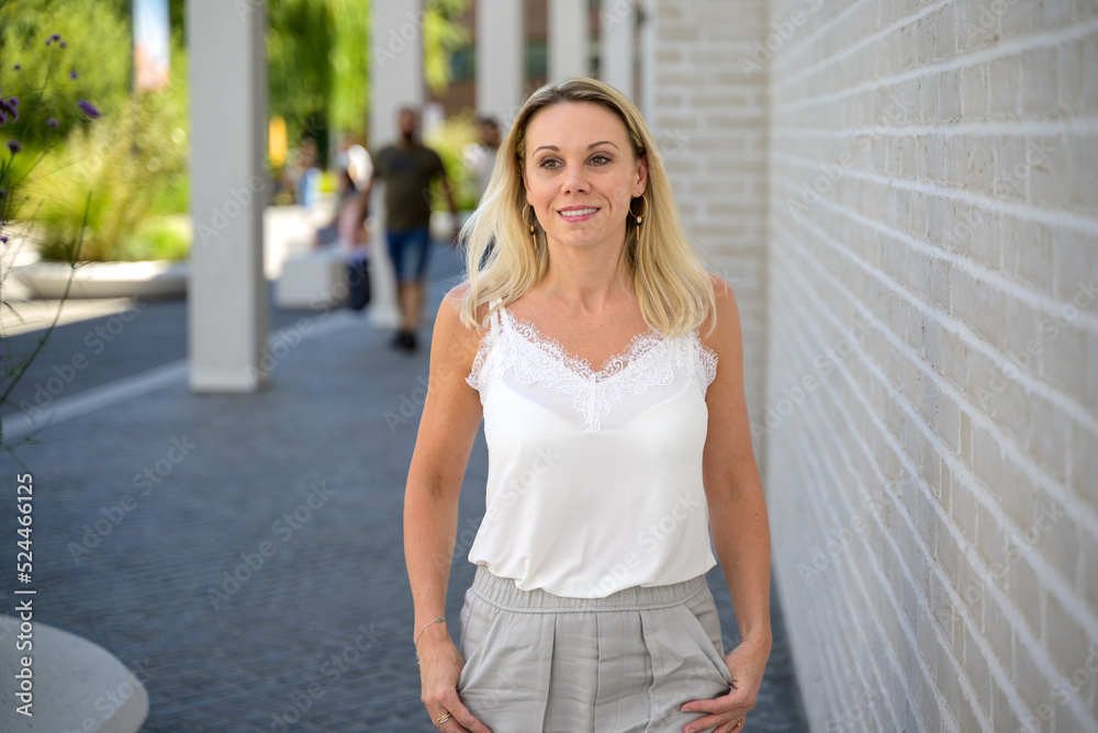 Obraz premium Blond woman walking through town wuth a preoccupied expression