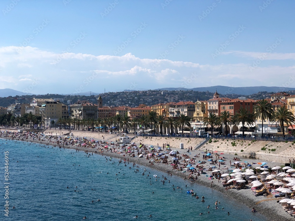 Panoramic view of Nice with blue sea, beach, tourists, palms, colorful buildings on a sunny summer day, Côte d'azur, Mediterranean Sea, France, 2022
