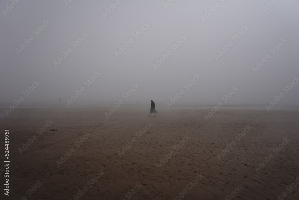 women walking in the mist on the beach