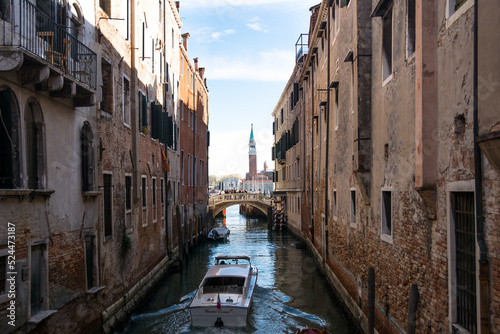 View of a narrow canal and boat and ancient buildings at Venice, Veneto, Italy.
