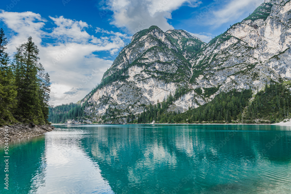 Braies lake in Dolomites, Italy. Landscape with mountains, water with reflection, trees. Travel in italian alps. Nature