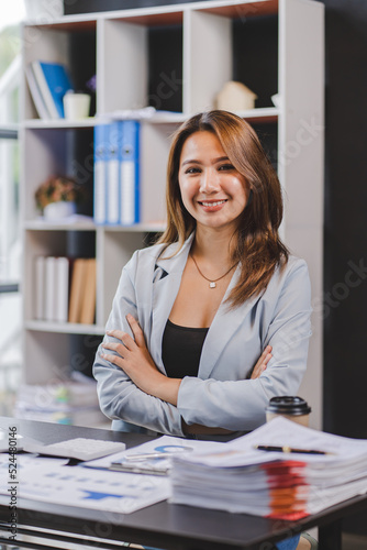 Smiling Asian businesswoman working on laptop in modern office Accountant Concept Finance Expert Analyze Business Report Graph financial chart financial chart corporate economy Banking Market Research