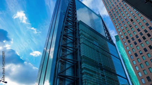 A timelapse of cloud reflecting the building in the business town wide shot tilt