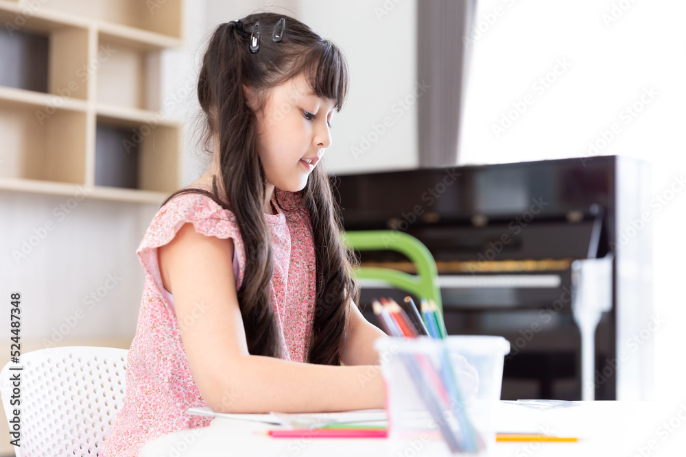 happy smiling young asian student student girl with colour pencil for do a homework after campus or school at living room for learning happy smiling young asian student student girl with colour pencil for do a homework after campus or school at living room for learning