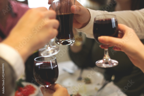 Defocus toasting glasses background. Clinking glasses with alcohol and toasting, party. Company of friends. Celebrating holiday concept. Out of focus photo