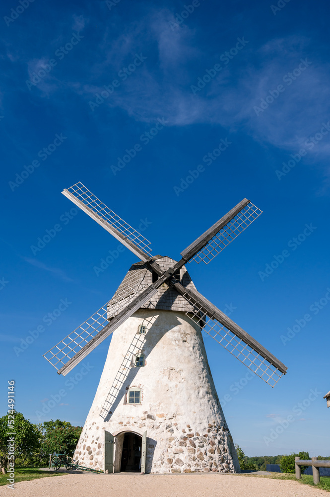 Dutch-type windmill in Araisi, Latvia. Sunny summer day. Old Europe style. Blue sky. Green grass.