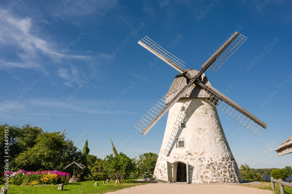 Dutch-type windmill in Araisi, Latvia. Sunny summer day. Old Europe style. Blue sky. Green grass.