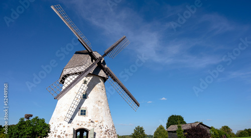 Dutch-type windmill in Araisi, Latvia. Sunny summer day. Old Europe style. Blue sky. Green grass.