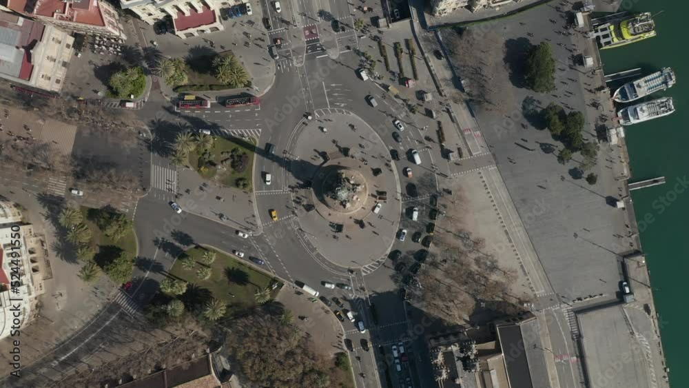 Birds eye shot of large multilane roundabout around famous landmark. Vehicles passing along Columbus Monument. Barcelona, Spain Birds eye shot of large multilane roundabout around famous landmark. Vehicles passing along Columbus Monument. Barcelona, Spain