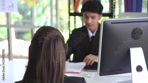Asian woman is taking a job interview with a male boss in an office.