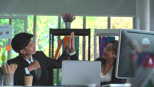 Business couple putting hand Hi Five together for success in office co working.