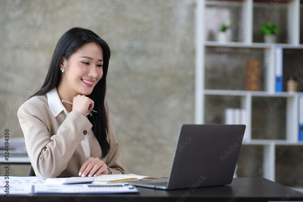 Attractive beautiful Asian business woman working on laptop on desk in office. Attractive beautiful Asian business woman working on laptop on desk in office.