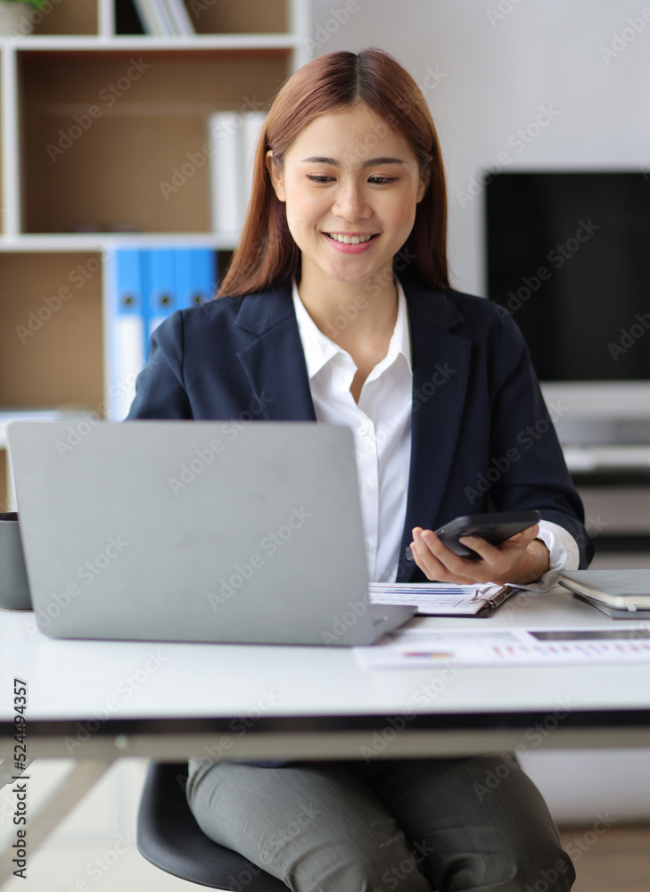 Businesswoman looking at financial information from a mobile phone, she is checking company financial documents, she is a female executive of a startup company. Concept of financial management. Businesswoman looking at financial information from a mobile phone, she is checking company financial documents, she is a female executive of a startup company. Concept of financial management.