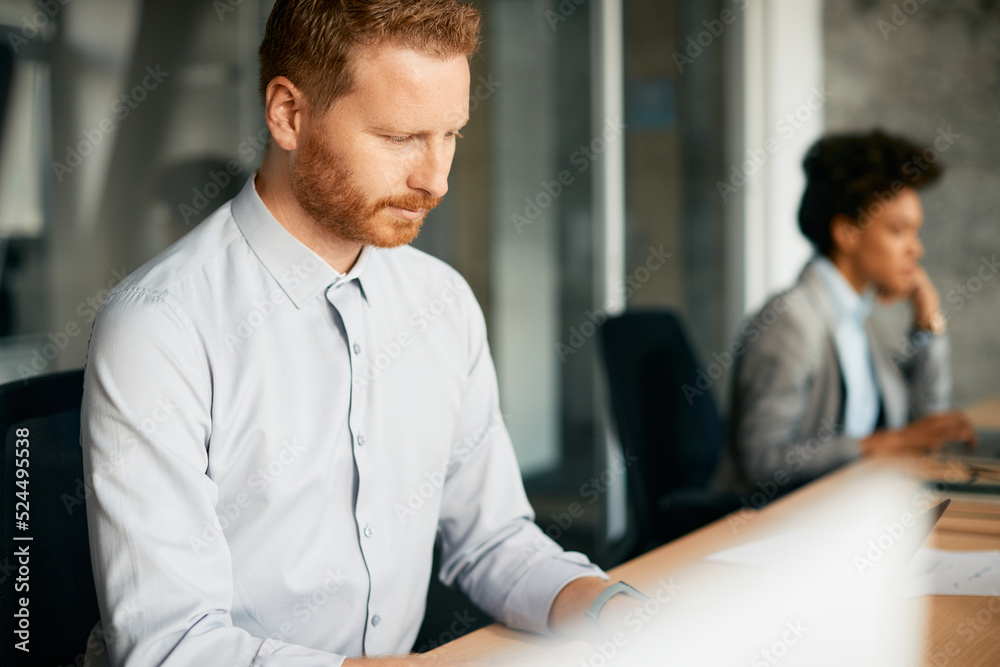 Male entrepreneur working on computer in office. Male entrepreneur working on computer in office.