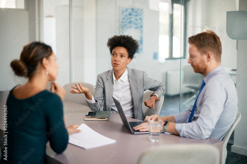 Multiracial business team discussing during meeting at corporate office. Multiracial business team discussing during meeting at corporate office.